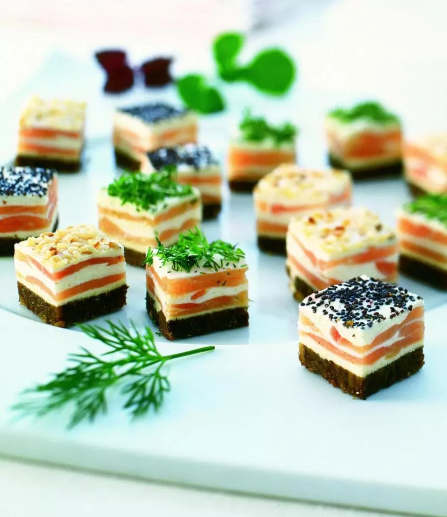 Lachs-Törtchen auf Pumpernickel mit Kräutern garniert