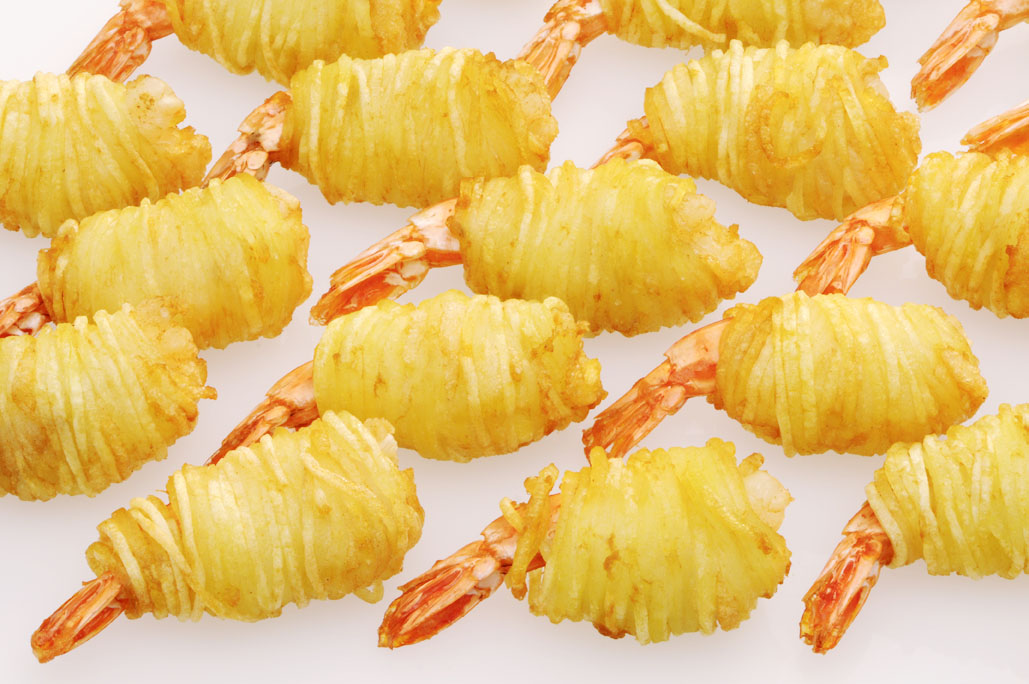 Garnelen umwickelt mit knusprigem Kartoffelteig auf weißem Hintergrund