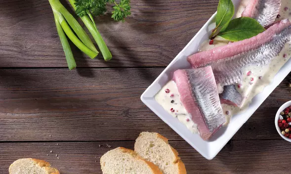 Matjesfilets in Sahnesoße mit Gewürzen auf Teller angerichte