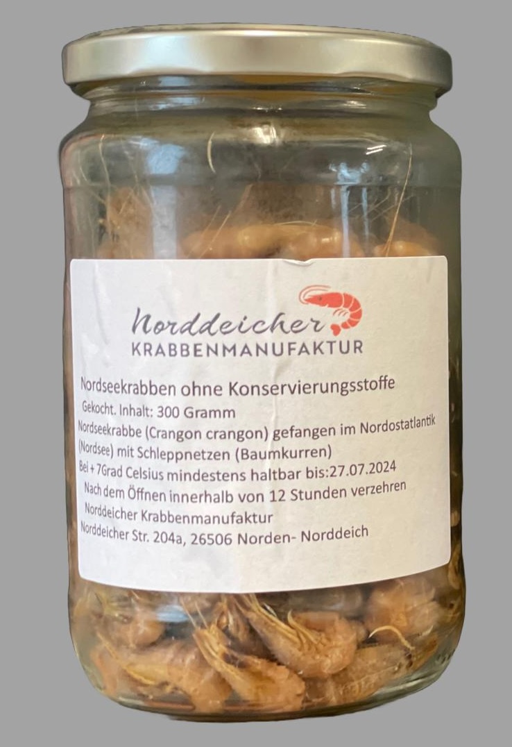 Glas mit gekochten Nordseekrabben, sichtbar durch das Glas