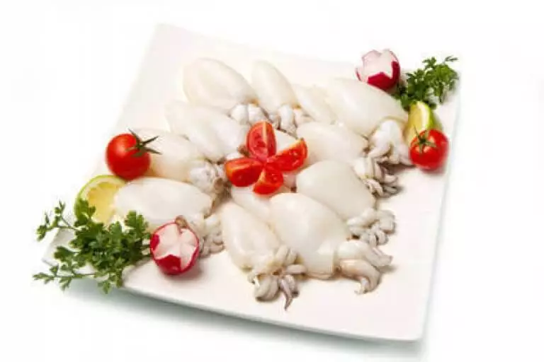 rohe Baby Sepia auf Teller mit Gemüse dekoriert