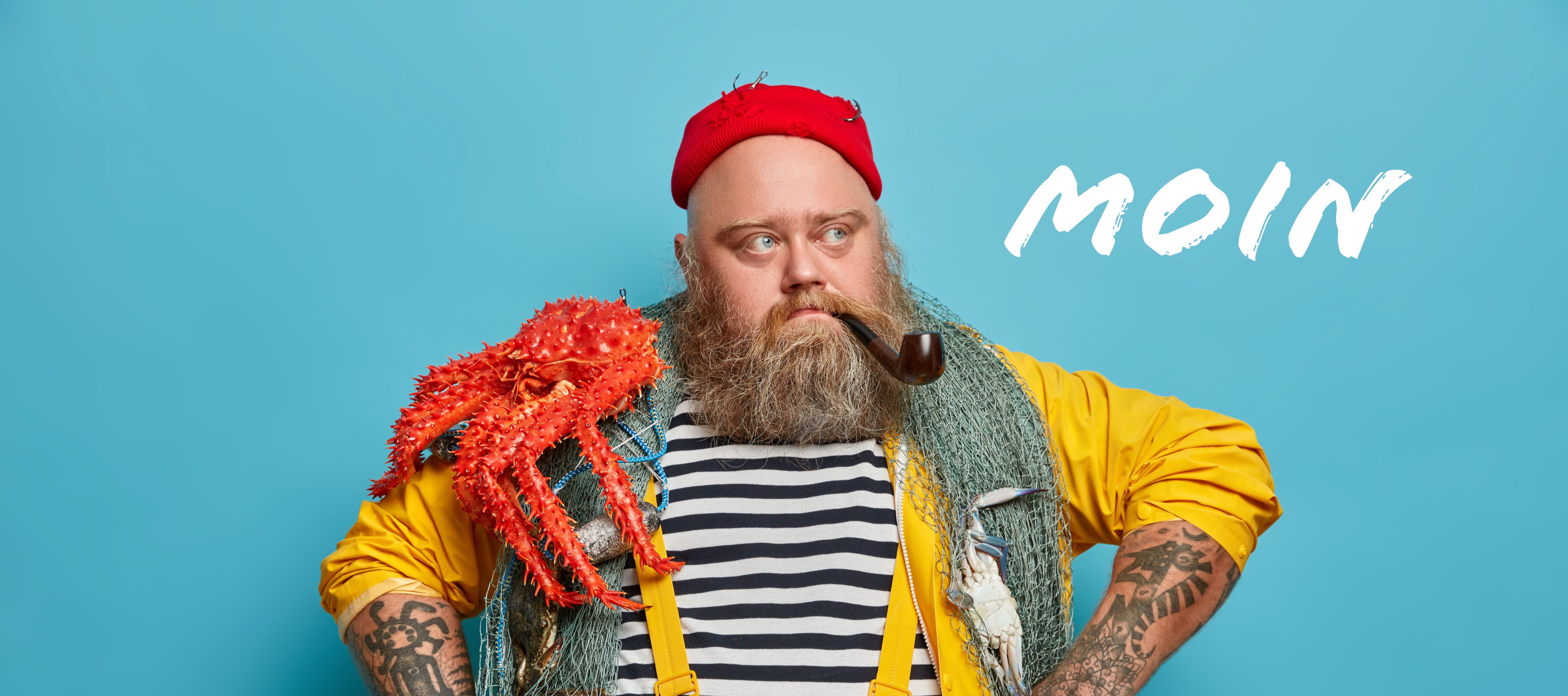Mann mit gelbem Regenmantel, roter Mütze, Pfeife und rotem Krebs auf der Schulter vor blauem Hintergrund mit Schriftzug "Moin"