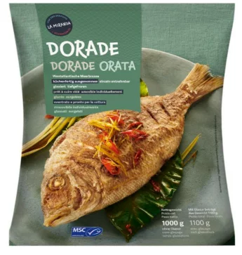 ganze Dorade auf grünem Teller dekoriert