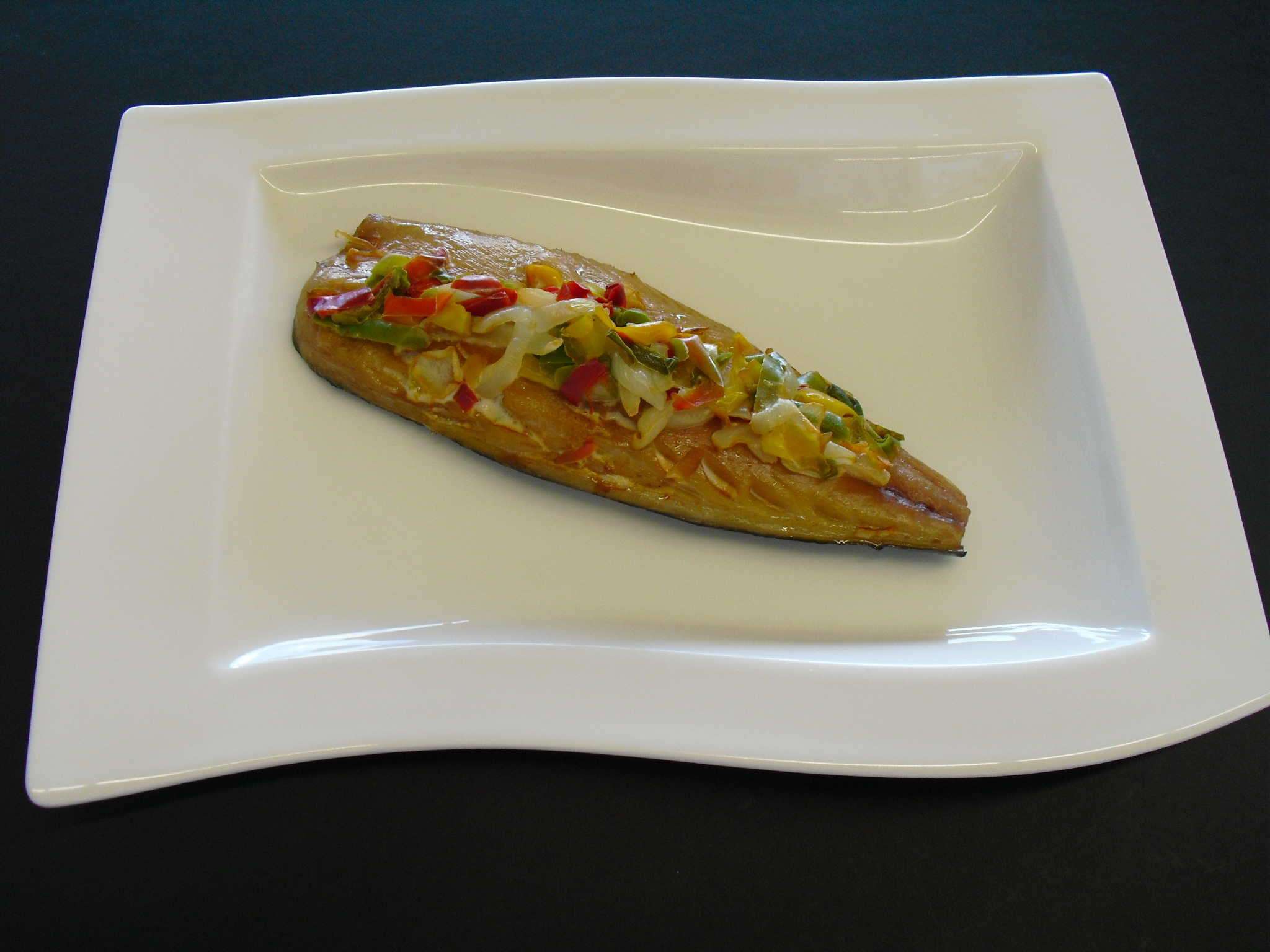 Geräuchertes Fischfilet mit buntem Gemüse, serviert auf einem eleganten weißen Teller