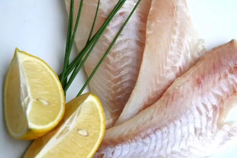 rohes Seelachsfilet mit Zitronenspalten und Schnittlauch